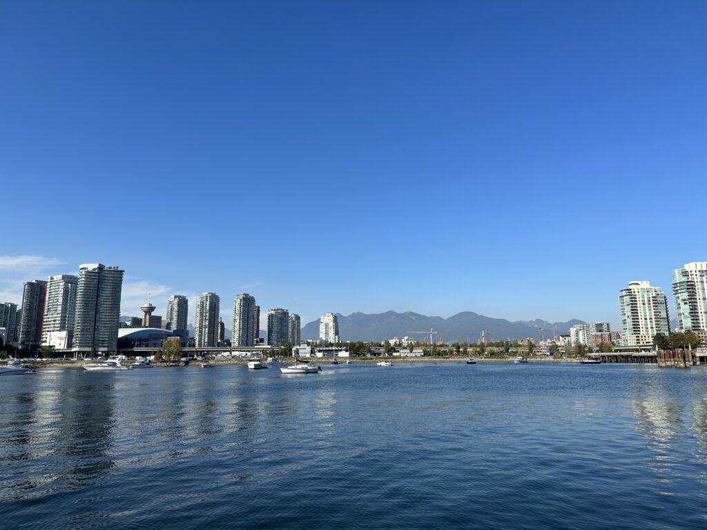 Vancouver downtown seen from the water, with buildings and mountains in the back