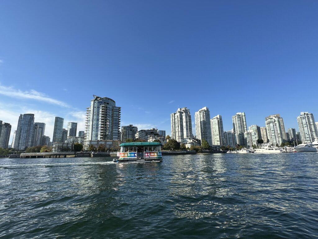 Vancouver downtown seen from the water with a creek ferry sailing past