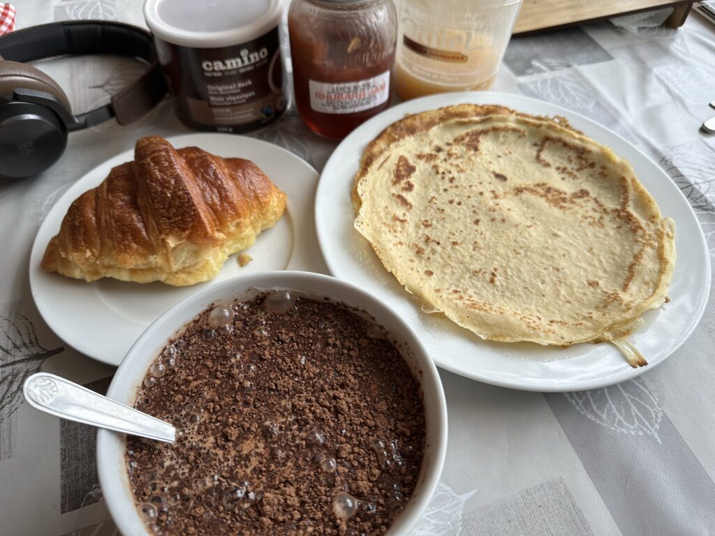 Breakfast with hot chocolate, croissant, and French crepes