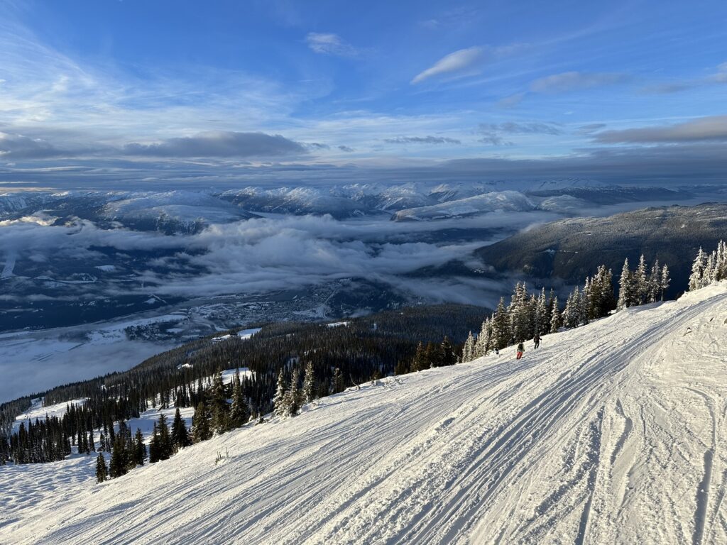 A nice view of the Canadian Rockies with snow covered tops and a valley hidden under a low cloud cover