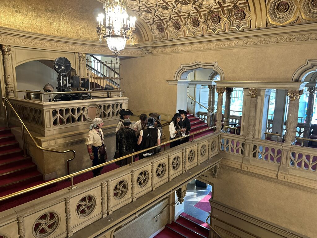 A group of people (among many others) dressed in pirate costumes, waiting at a balcony of the Orpheum theatre in Vancouver, BC.