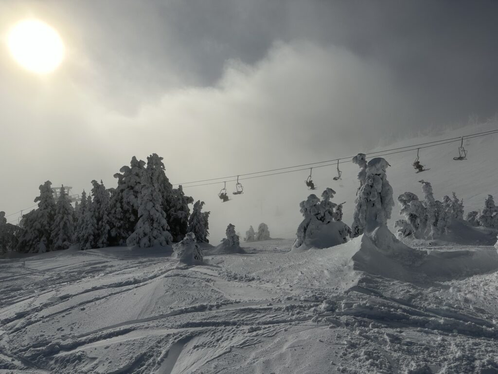 A chair lift lit from behind in a light fog in Sun Peaks, BC