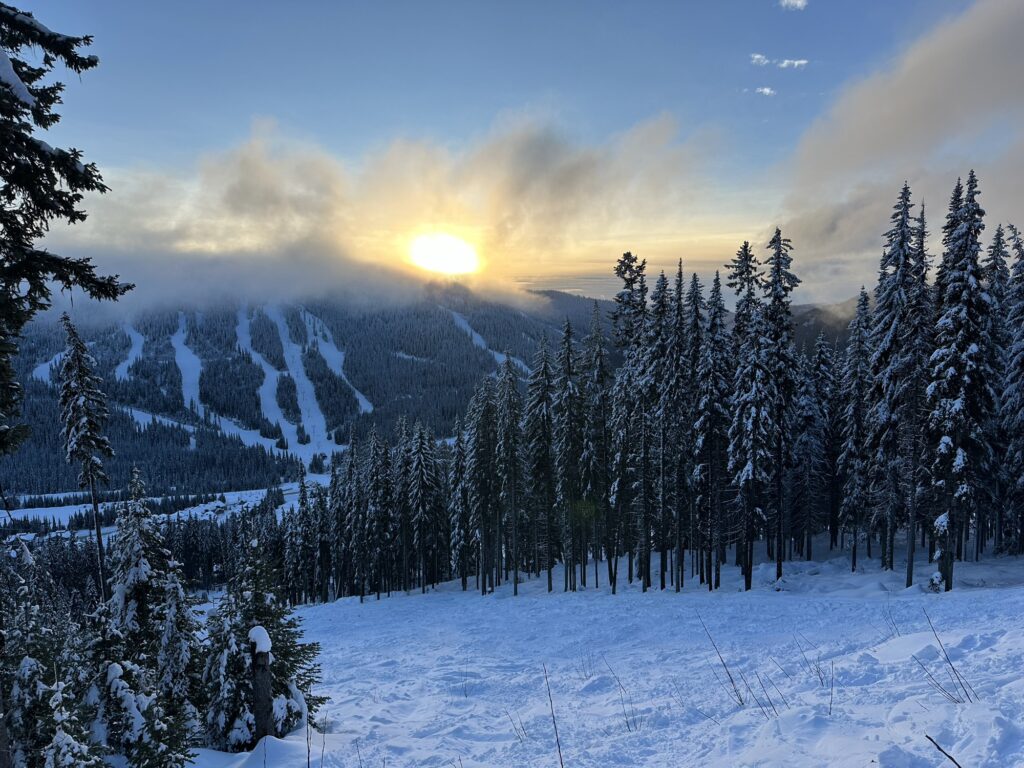 The sun sets behind mount Morissey in Sun Peaks, BC