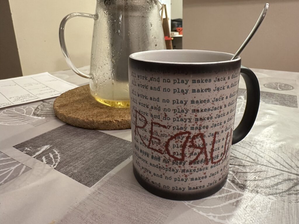 The other side of the mug while hot tea has been poured in it. The side of the mug is filled with "All work and no play makes Jack a dull boy", and "REDRUM" is written in large red letters across the side. Of course, this isn't visible when no hot beverage is in the mug.