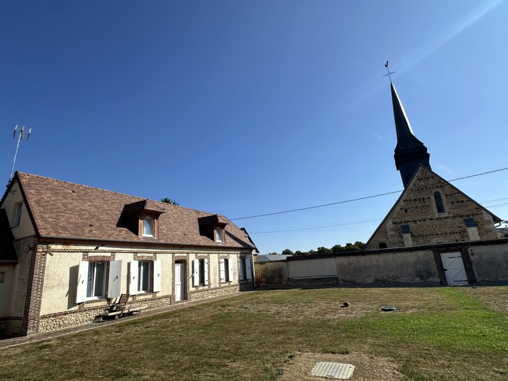 Part of the clergy house on the left, with the church visible behind the outer wall.
