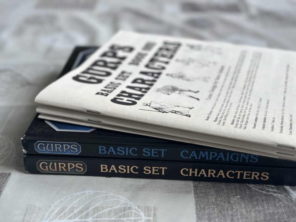 First edition GURPS booklets on top of the 4th edition's Characters and Campaigns books.