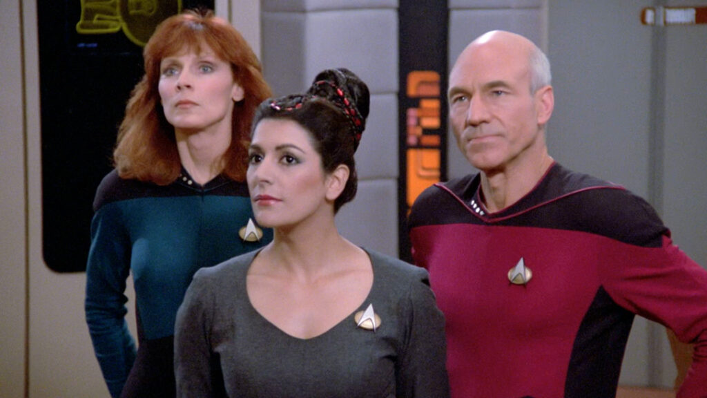 Crusher, Troi, and Picard standing somewhere in the Enterprise. Of all the TNG characters, I think Troi is the only one I find "meh" so far. 