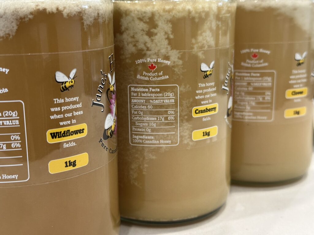 Three jars of "Jane's Honey Bees", made here in BC. I haven't tasted it yet but different labels for different fields of flowers is, at least, encouraging!

In this case, it's wildflower, cranberry, and clover fields.