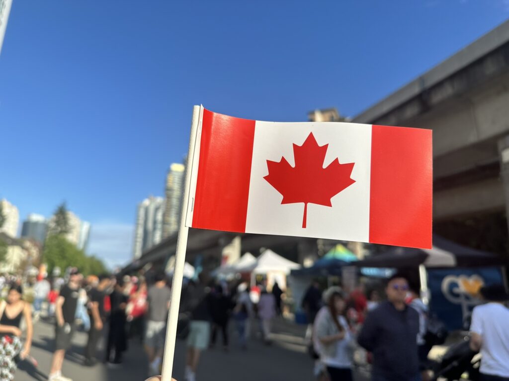 The Canadian flag being waved around StreetFest in Burnaby, BC.
