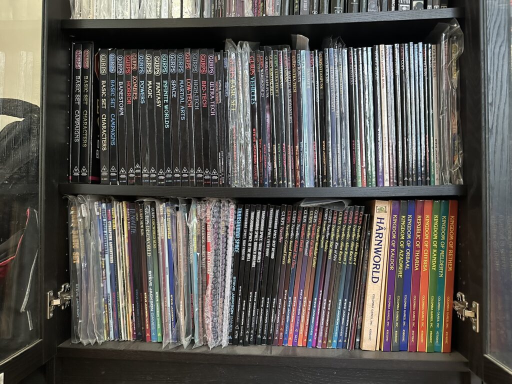 A picture of my "nerdy RPGs" shelves, with mostly GURPS book, plus a few Harnworld books in the lower-right.

The GURPS collection includes a fairly complete set of 4e books, a quite lengthy collection of 3e/2e books (including a few obscure ones), a partial GURPS Traveller collection, and a complete GURPS Transhuman Space collection.