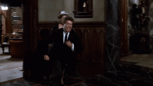 Tim Curry in the Clue movie, trying to break down a door and failing miserably.