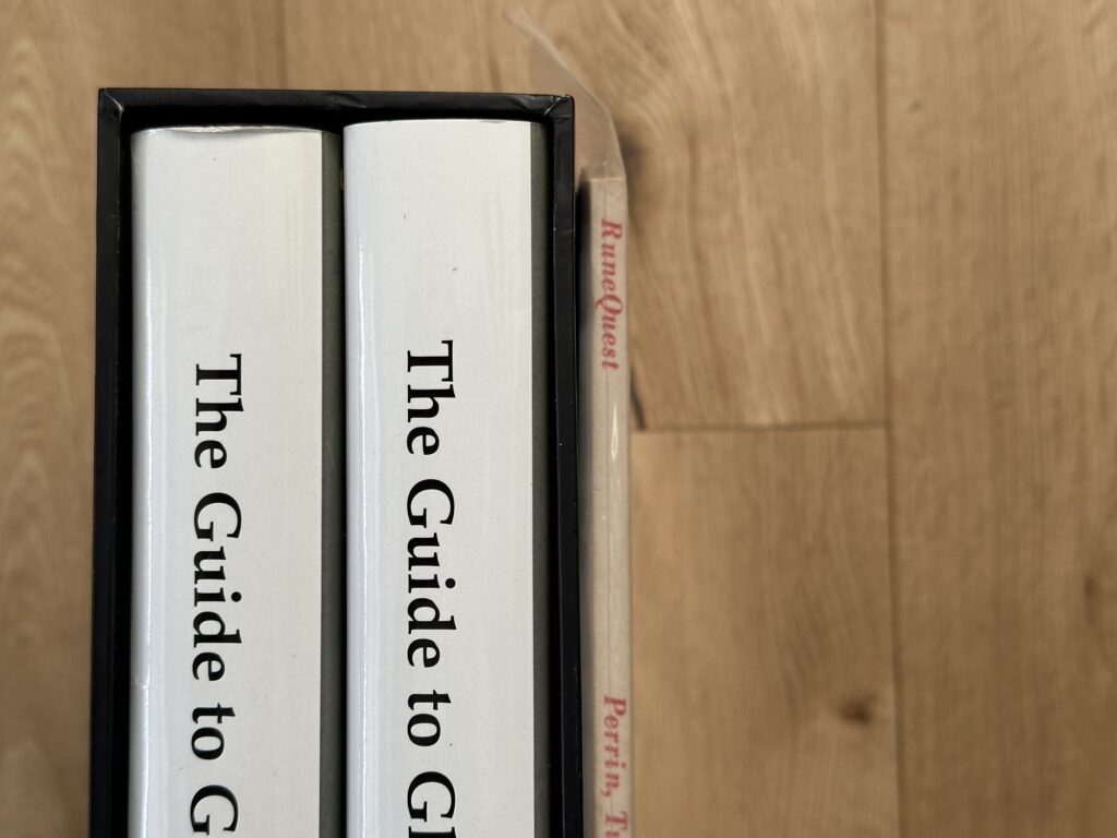 The Guide to Glorantha slipcase, and the RuneQuest 2e rulebook sitting against it.